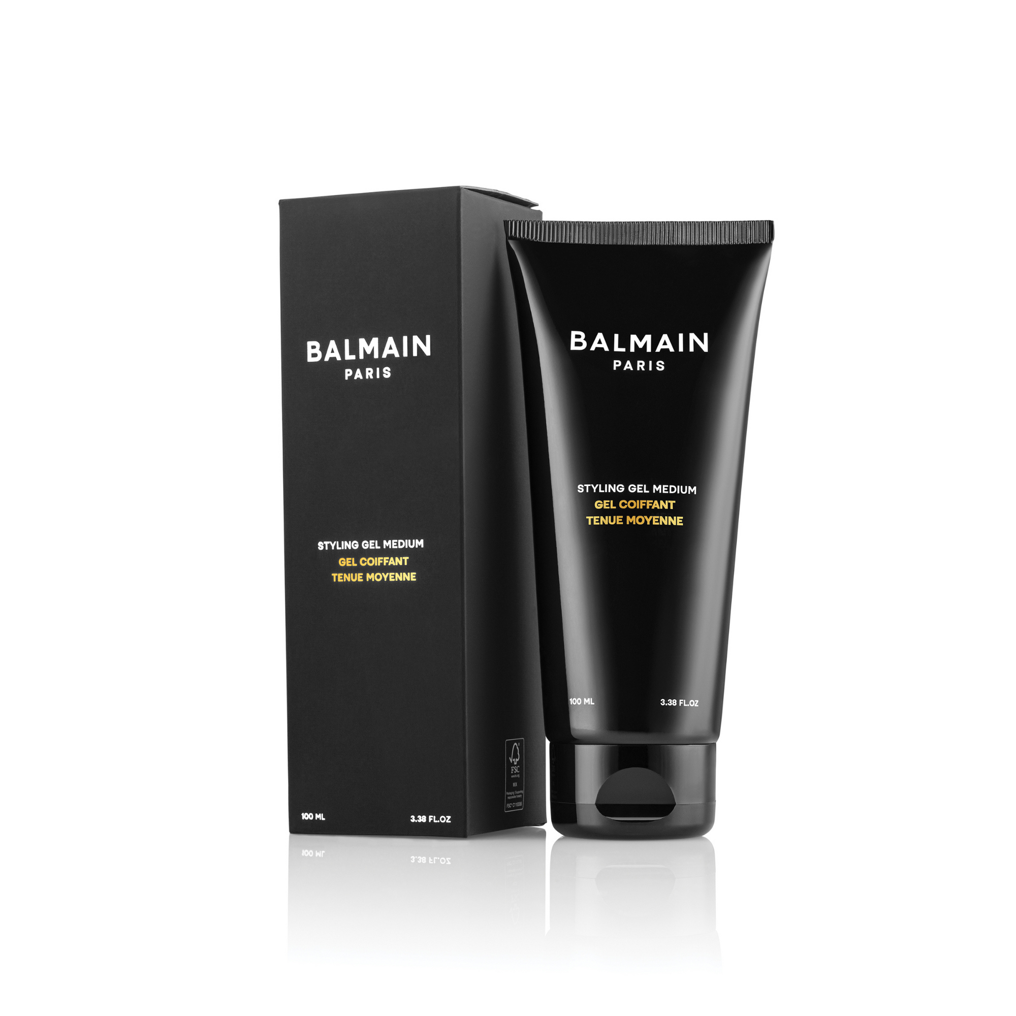 A tube of Balmain Styling Gel Medium Hold with the product box behind it. The packaging is primarily black with yellow and white text, and the tube is dark blue with the brand name prominently displayed.