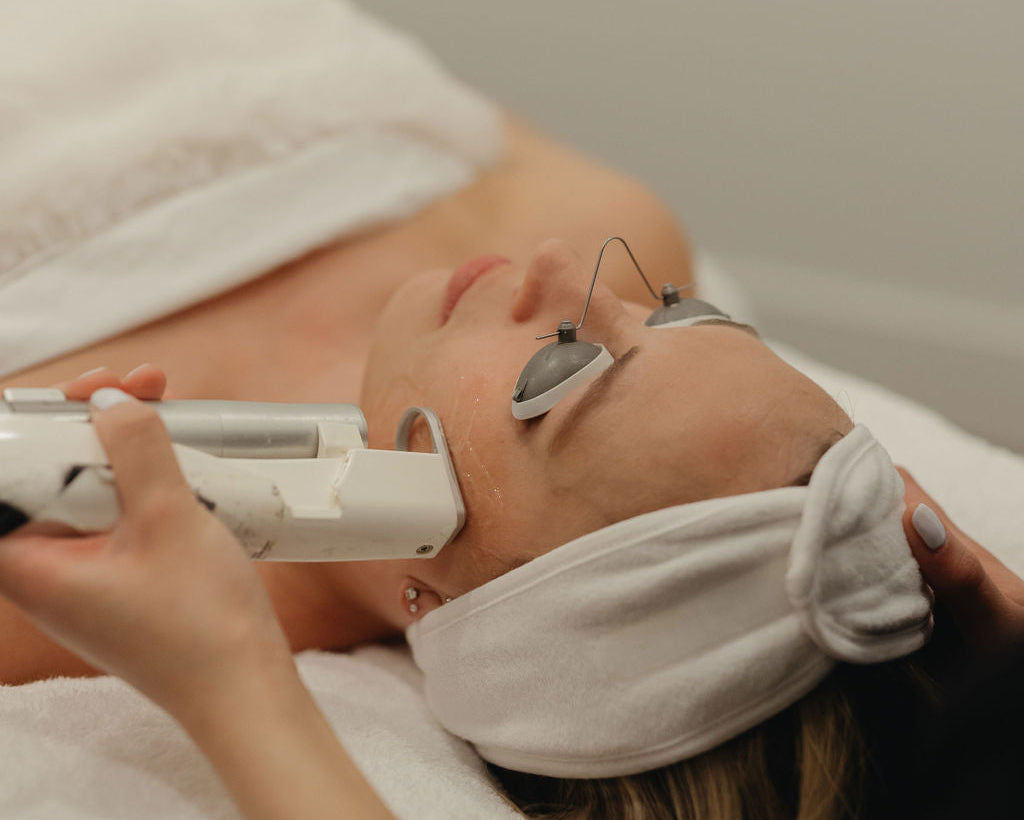 Woman receiving a facial treatment with a Quanta laser hair removal device on her face.