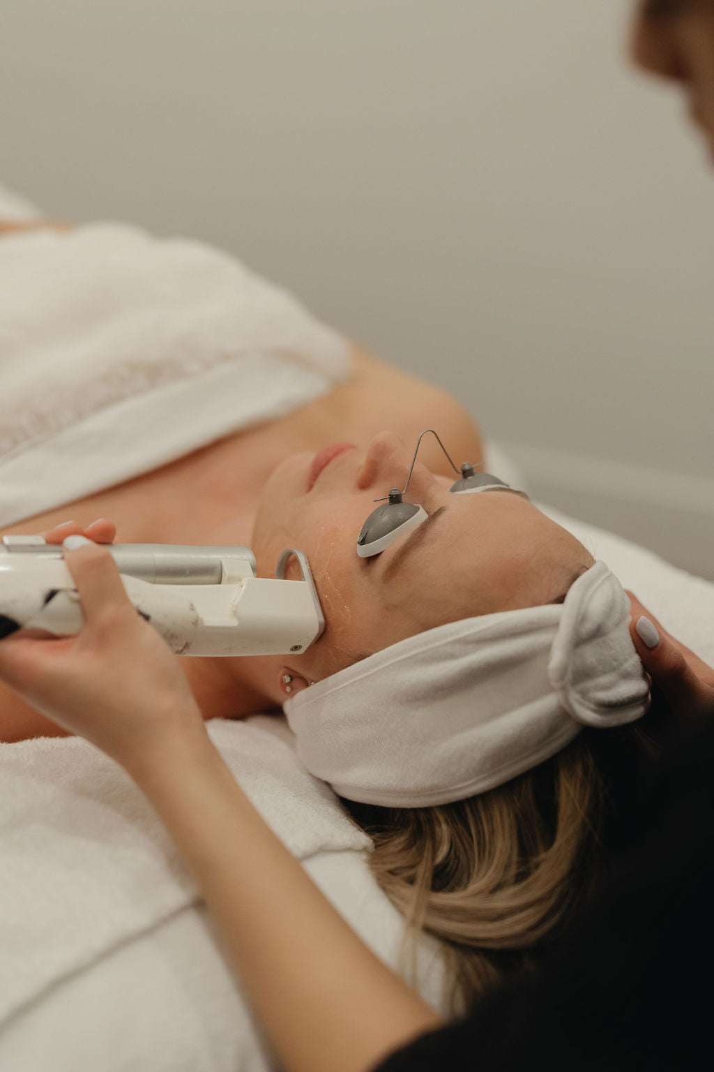 Woman receiving a facial treatment with a Quanta laser hair removal device on her face.